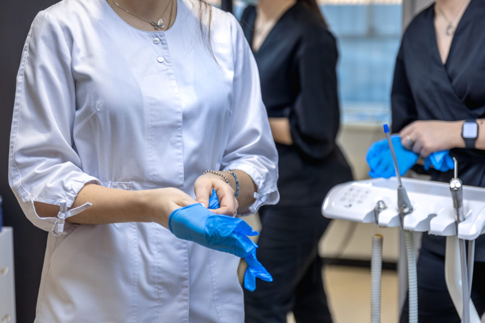 A woman dentist puts a rubber glove on her hand. dentistry concept.